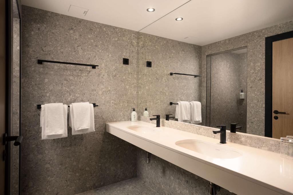 a bathroom with two sinks and a large mirror at Scandic Victoria in Oslo