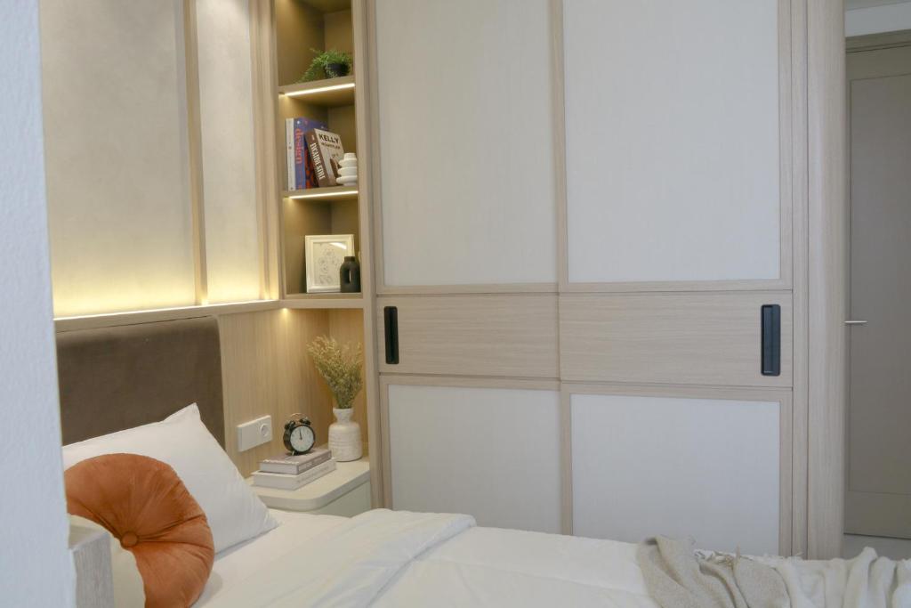 a bedroom with a white cabinet and a bed at Japandi Style One-Bedroom Apartment Gold Coast PIK in Jakarta