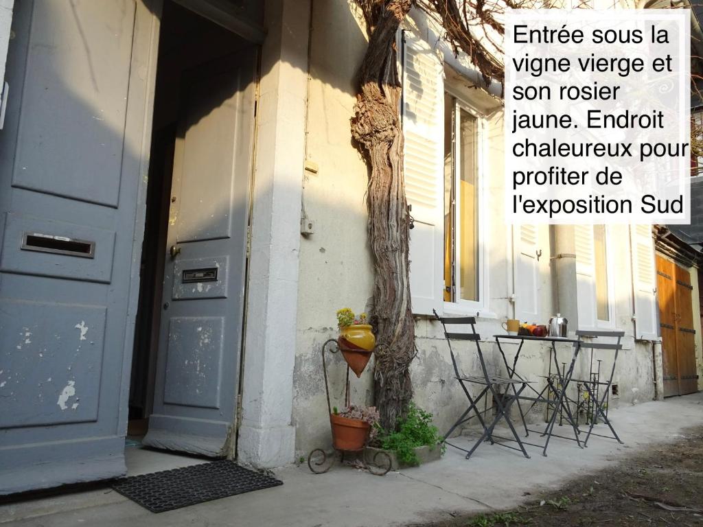 a tree sitting next to a house with a blue door at Chaleureux Henri IV in Pau