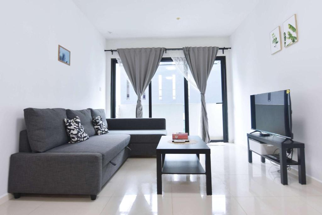 a living room with a couch and a tv at Chic Suasana JB Suite Cozy Stay with Balcony in Johor Bahru