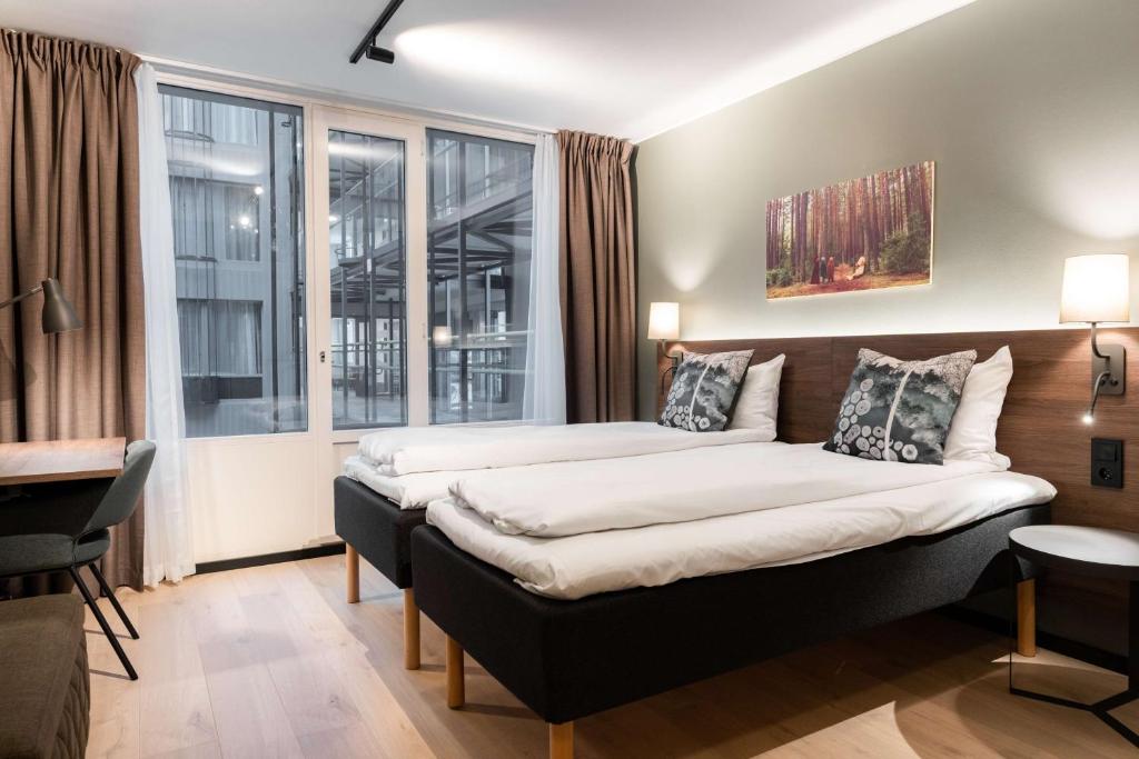 two beds in a room with a window at Scandic Hell in Hell