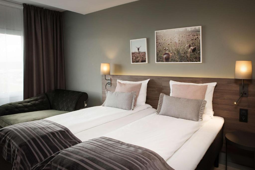 a hotel room with a large bed and a couch at Scandic Hell in Hell