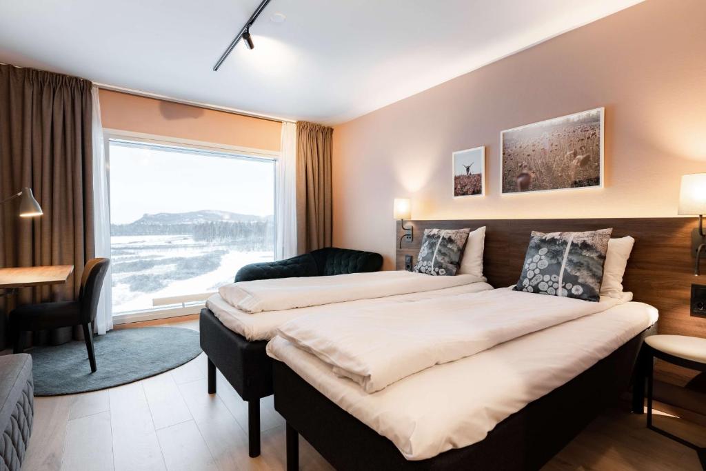 a bedroom with two beds and a large window at Scandic Hell in Hell