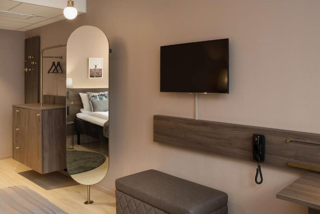 a room with a mirror and a tv on the wall at Scandic Hell in Hell