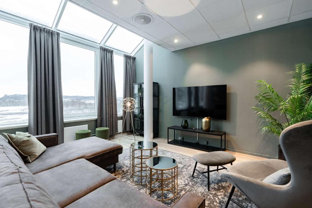 a living room with a couch and a tv at Scandic Hell in Hell