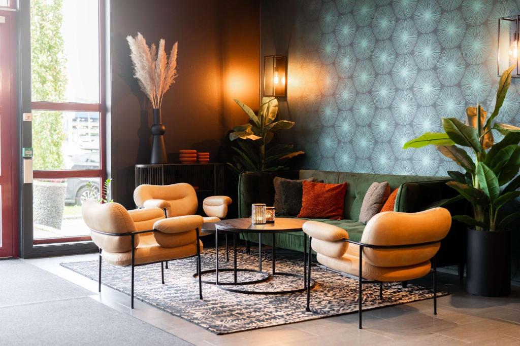 a living room with orange chairs and a couch at Scandic Hell in Hell