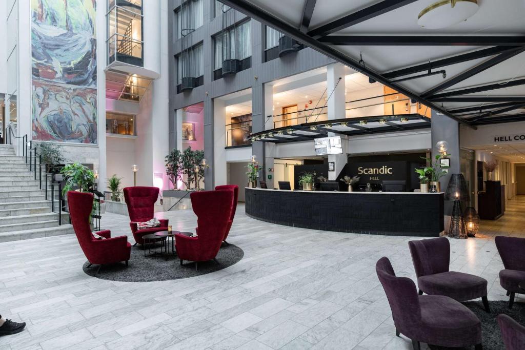 a lobby with chairs and a table in a building at Scandic Hell in Hell