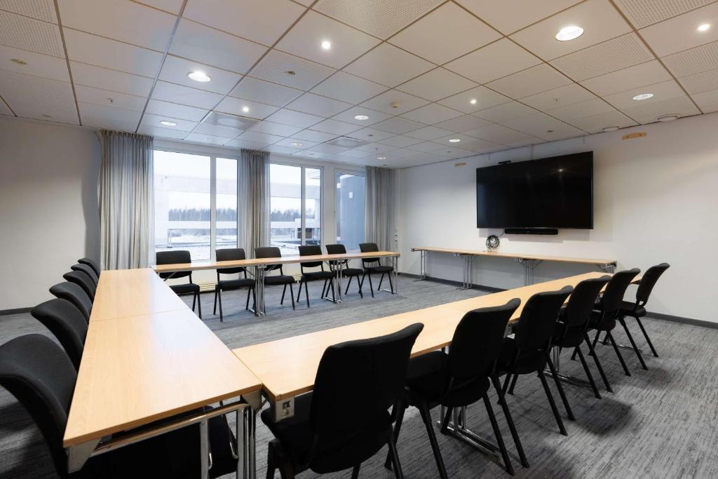 a conference room with tables and chairs and a flat screen tv at Scandic Hell in Hell