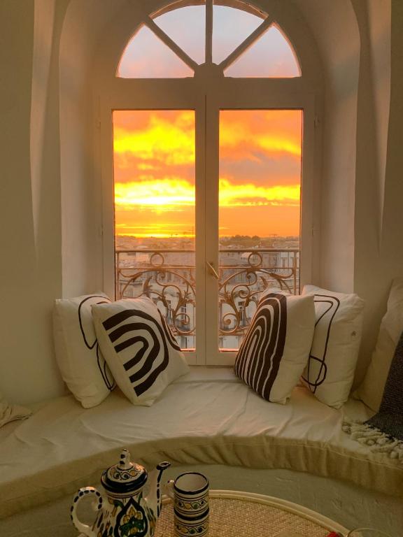 d'un siège près de la fenêtre offrant une vue sur le coucher du soleil. dans l'établissement Studio dans le centre historique avec WIFI et TV, à Montpellier