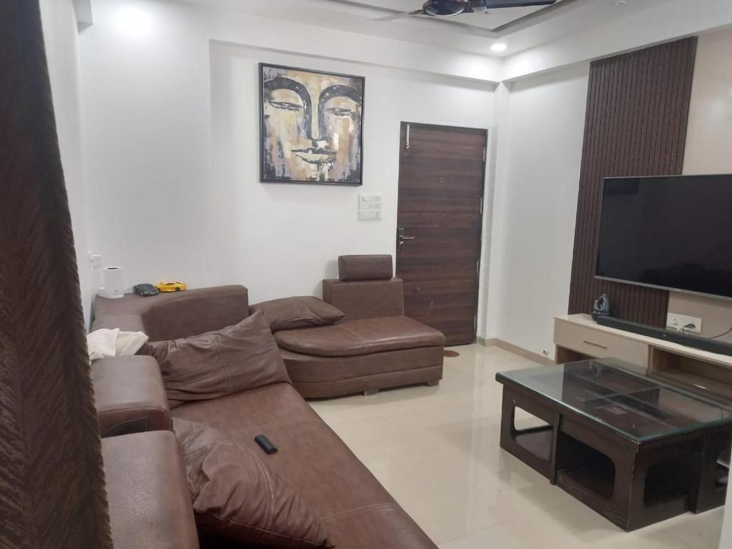 a living room with a couch and a flat screen tv at Stay comfort at City Heart 2Bhk AC ,WIFI & Much more in Indore