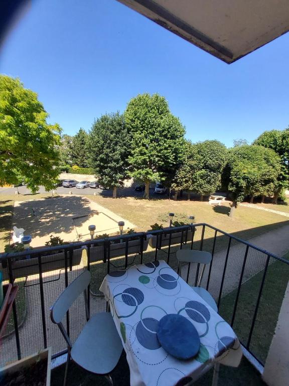 Il dispose d'un balcon avec une table et des plats bleus. dans l'établissement Appartement lumineux à 20mn de Paris en RER A, à Maisons-Laffitte