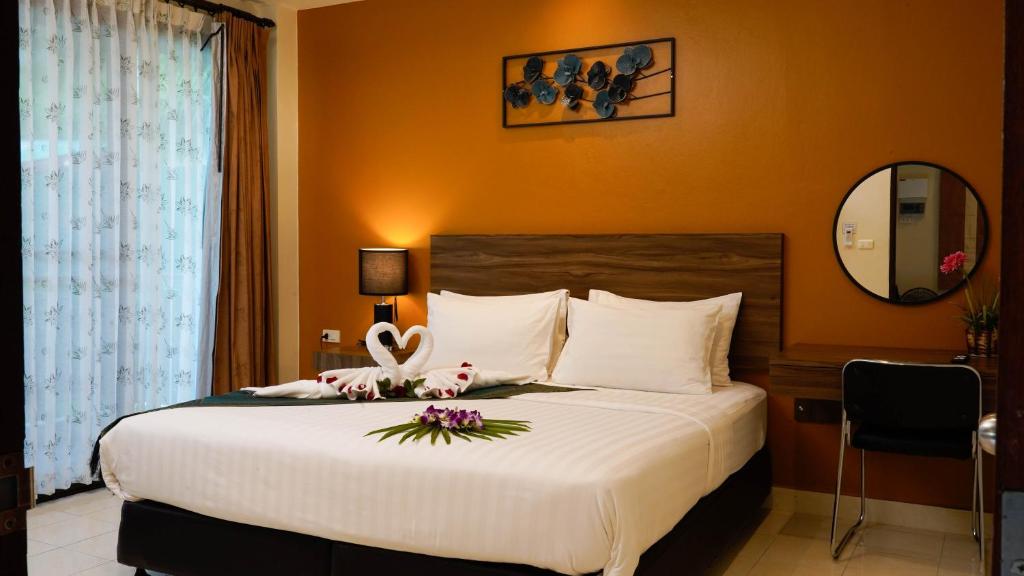 a bedroom with a large bed with flowers on it at Katanoi Resort in Kata Beach