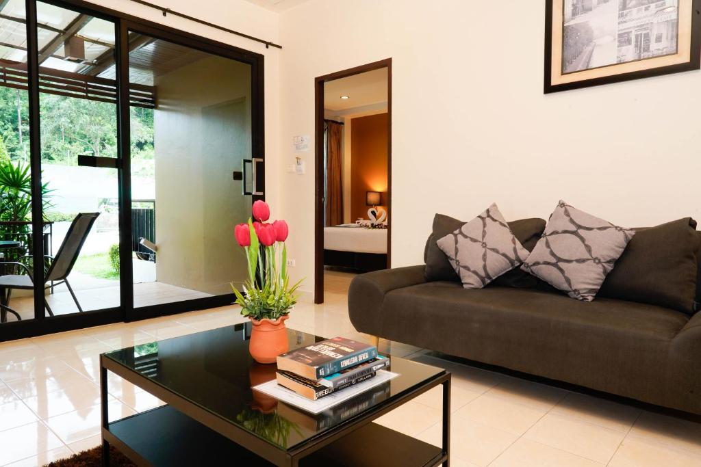 a living room with a couch and a coffee table at Katanoi Resort in Kata Beach