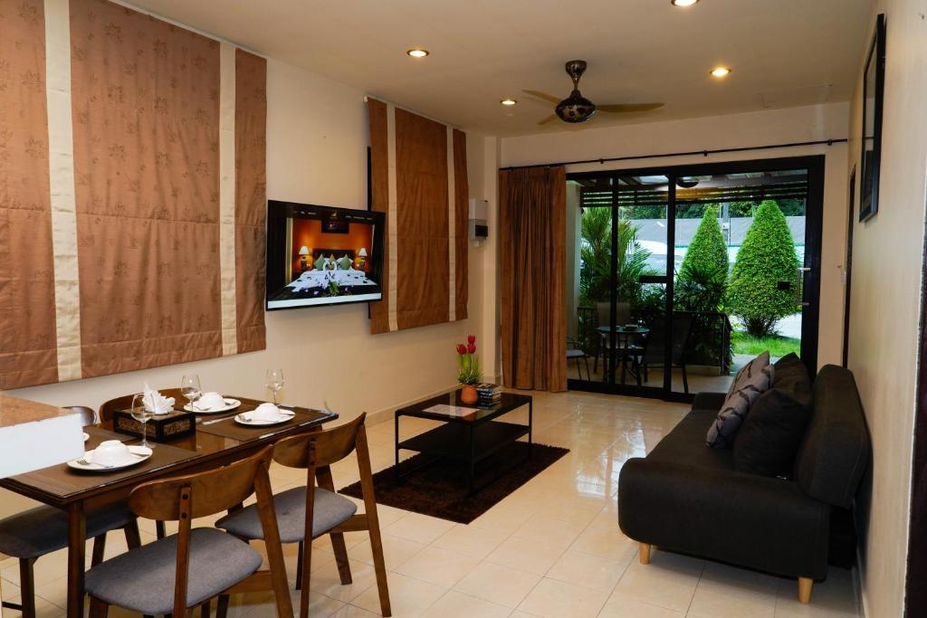 a living room with a table and a couch at Katanoi Resort in Kata Beach