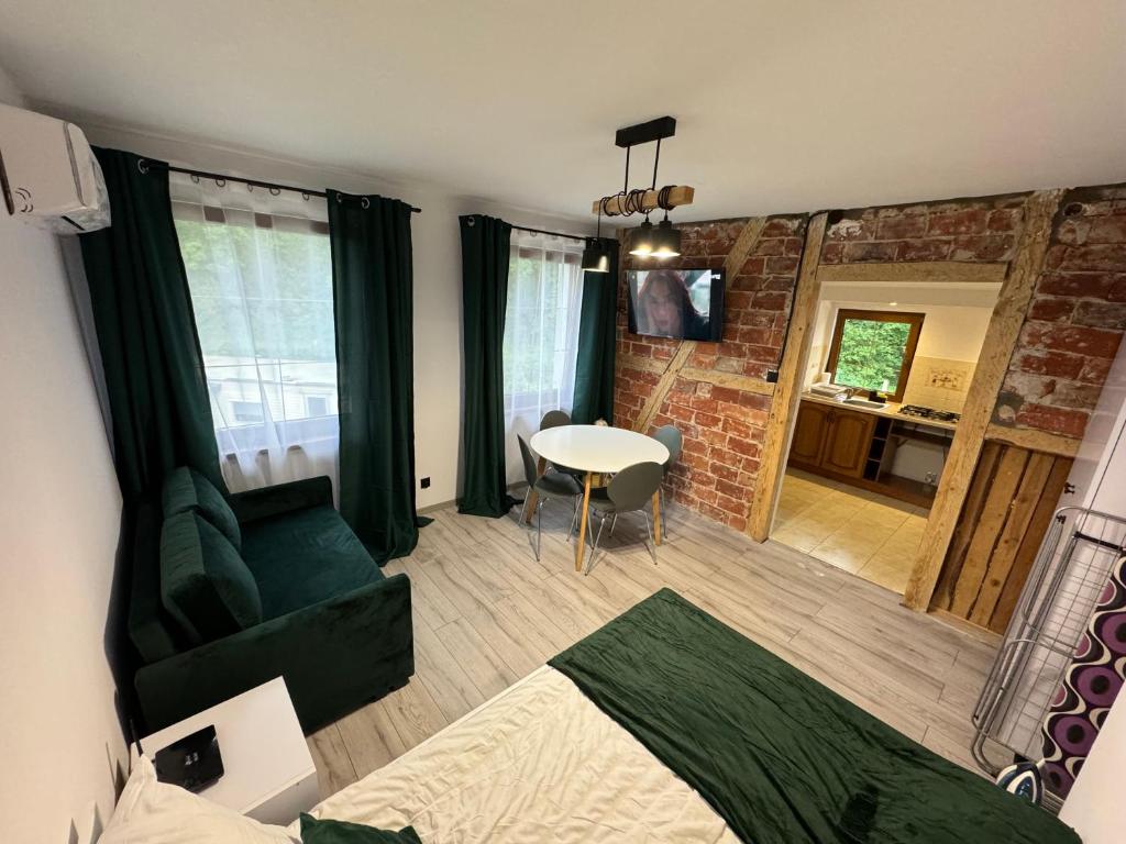 a living room with a green couch and a table at Noclegi u Kostka Sarbinowo in Sarbinowo