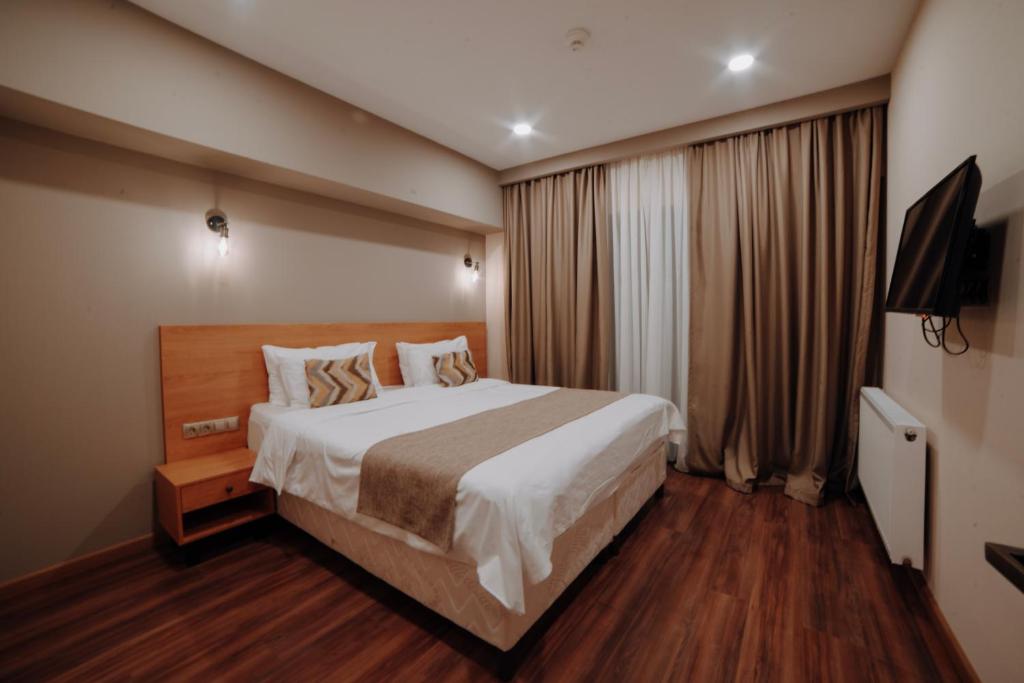 a hotel room with a large bed and curtains at Bakuriani Inn in Bakuriani