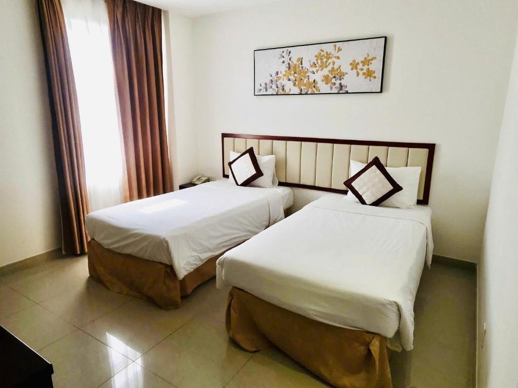 Postel nebo postele na pokoji v ubytování Lychees' Hotel