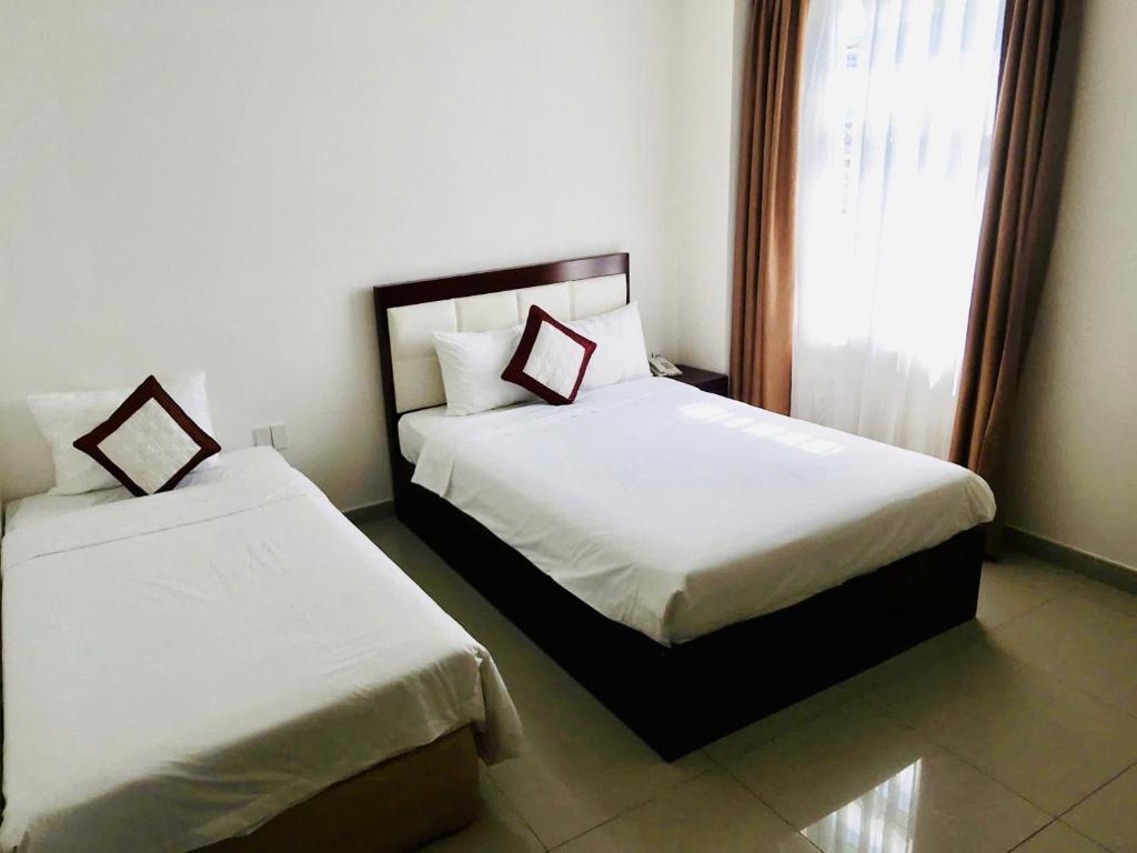 Postel nebo postele na pokoji v ubytování Lychees' Hotel
