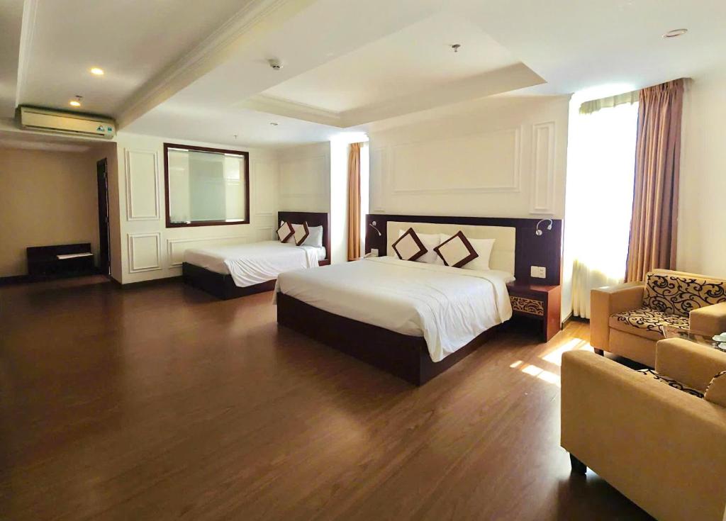 Postel nebo postele na pokoji v ubytování Lychees' Hotel