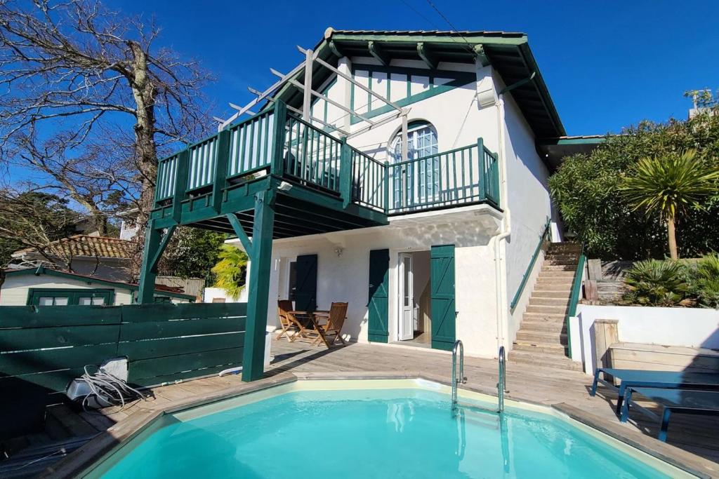 une maison avec une piscine devant une maison dans l'établissement Spacious house with beautiful garden, à Arcachon