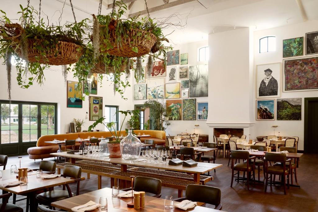 een restaurant met tafels en stoelen en foto's aan de muren bij Spier Hotel and Wine Farm in Stellenbosch