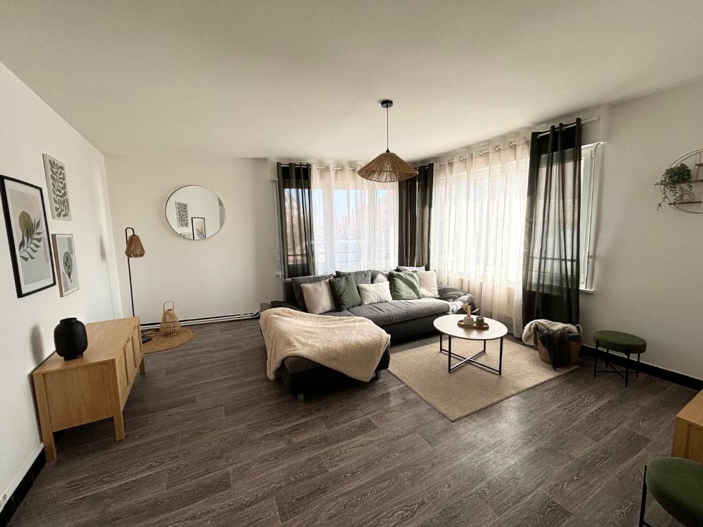 a living room with a couch and a table at Appartement spacieux et lumineux, 3 chambres à Coudekerque-branche in Coudekerque-Branche