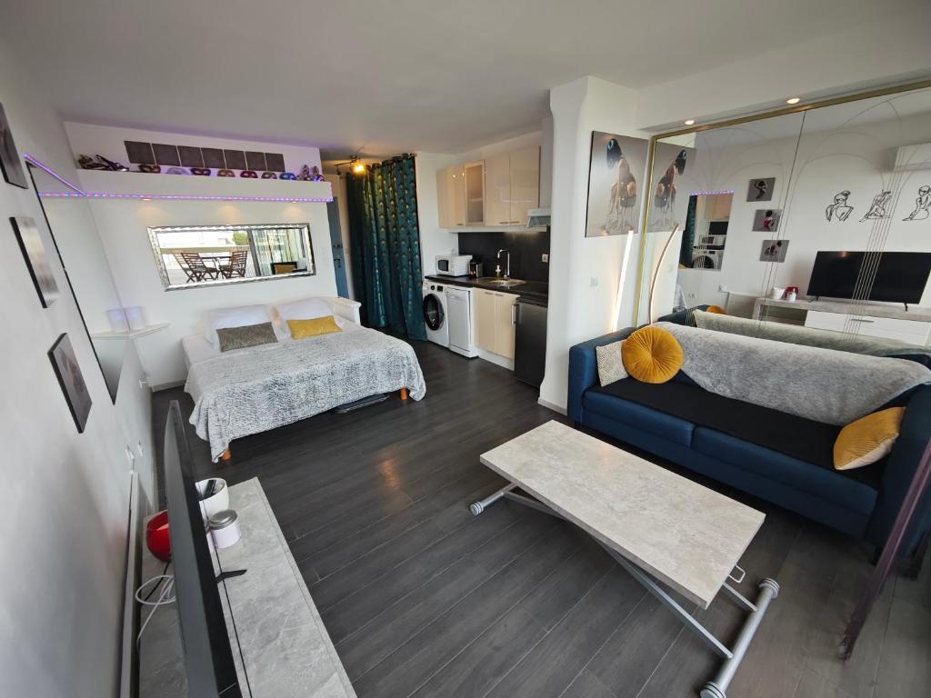 un salon avec un canapé et un lit dans l'établissement Studio Village Naturiste Resille, au Cap d'Agde