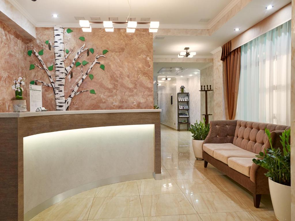 a lobby with a couch and a tree mural at Birch Yard Hotel in Rostov on Don