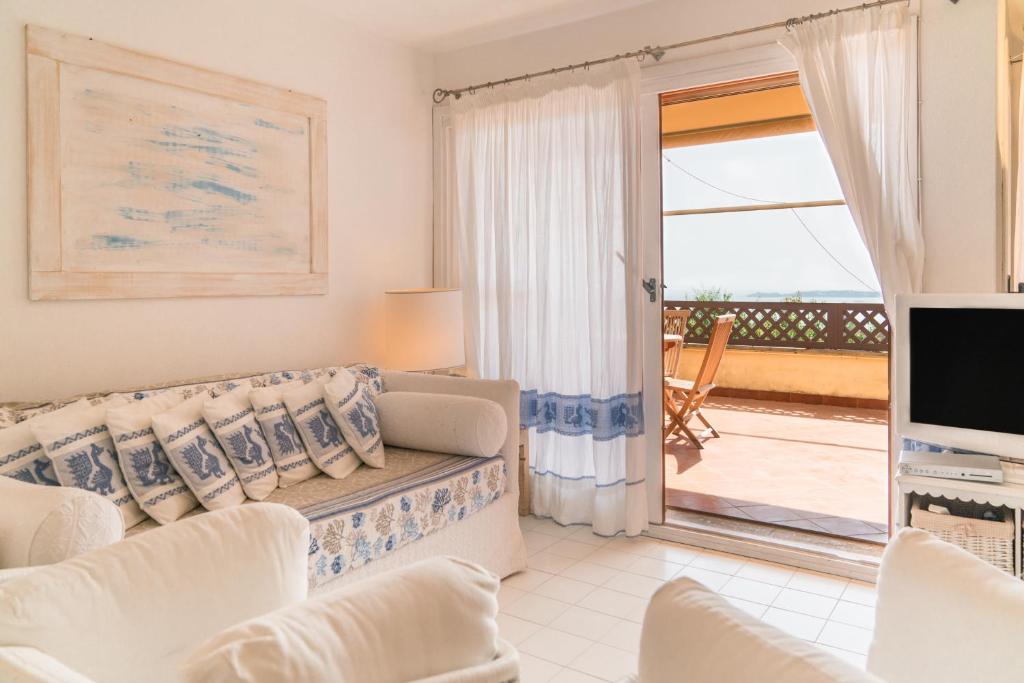 Una sala de estar con un sofá y un televisor. en Portisco1, en Marina di Portisco