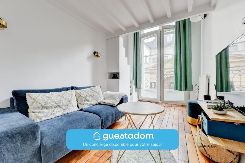 un salon avec un canapé bleu et une table dans l'établissement Le Renaud - Le Marais - Wifi - Balcon, à Paris