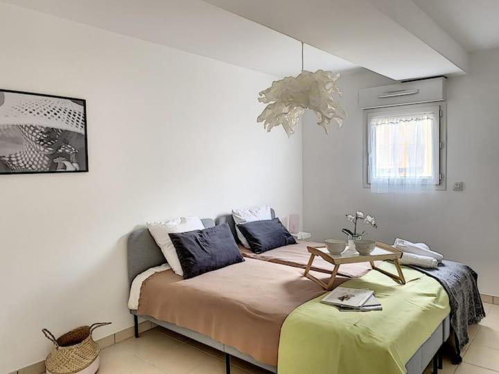 Cette chambre comprend un lit avec une table. dans l'établissement Bel appartement spacieux Sainte-Maxime Centre ville, à Sainte-Maxime