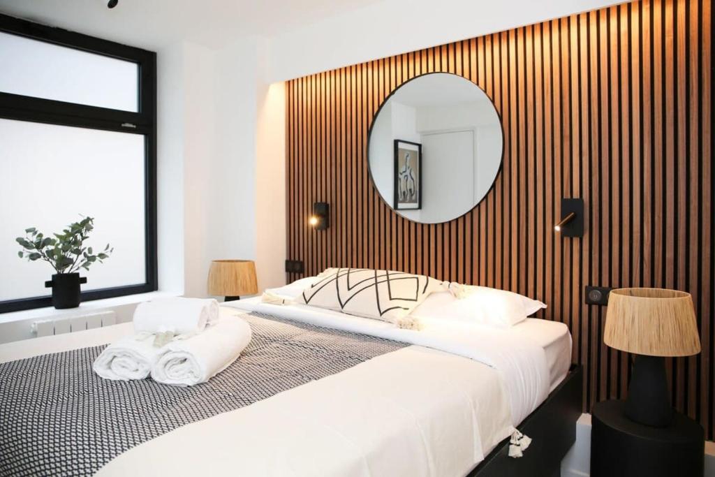 une chambre avec un grand lit et un miroir dans l'établissement Elegance et confort pres du Marais Cosy - 4P, à Paris