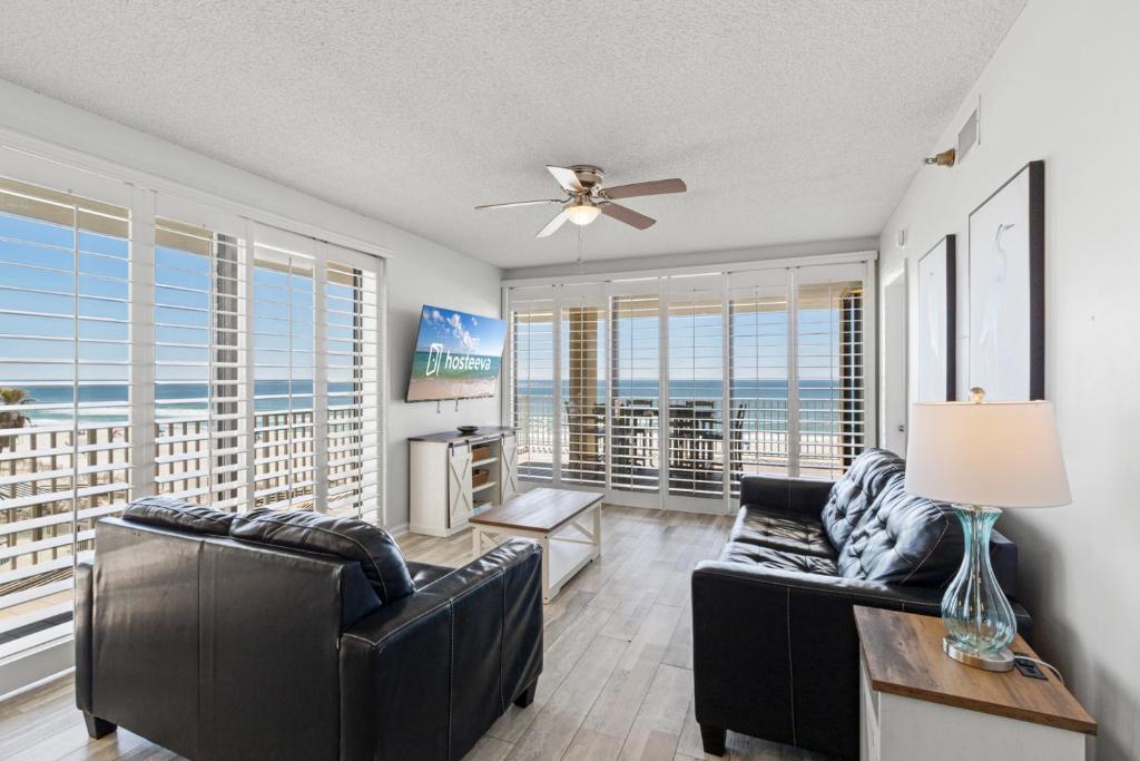 ein Wohnzimmer mit einer Couch und einem Deckenventilator in der Unterkunft Romar Place Condos in Orange Beach