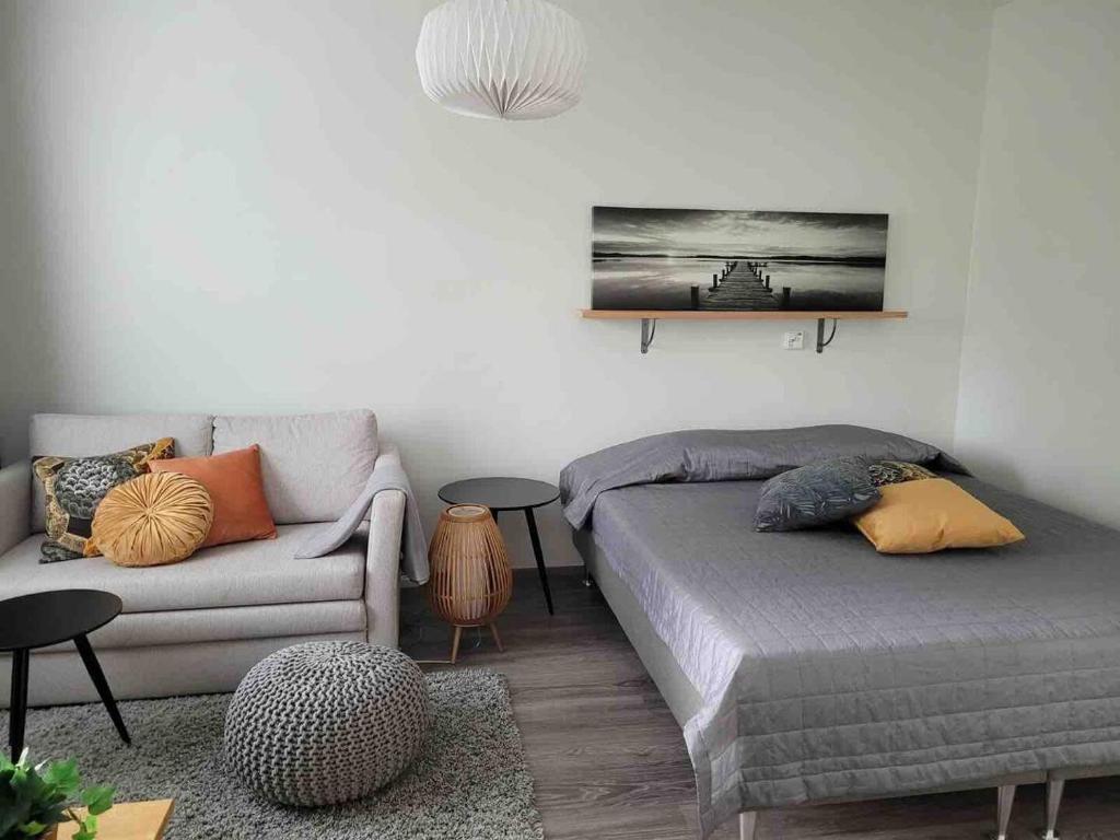 a living room with a bed and a couch at Modern apartment- great equipment - Smart TV -Fast Wifi, Close to the center in Lappeenranta