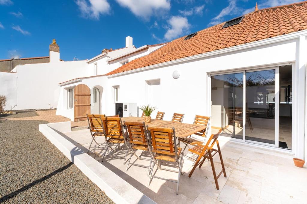 un patio avec une table et des chaises en bois dans l'établissement Propriété 8 suites avec jardin, à Challans