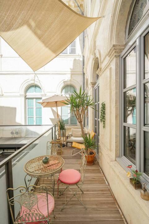 un patio avec une table et des chaises sur un balcon dans l'établissement Charme et confort, à Avignon
