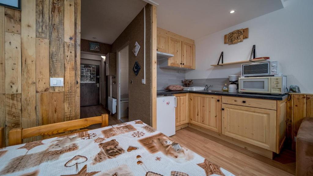 - une cuisine avec une table et un four micro-ondes dans l'établissement Les Marmottes N14 - ST4, à Allos