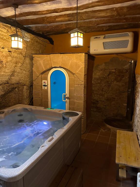 a large bath tub in a room with a blue door at Casa Rural La Tahona in Lerín