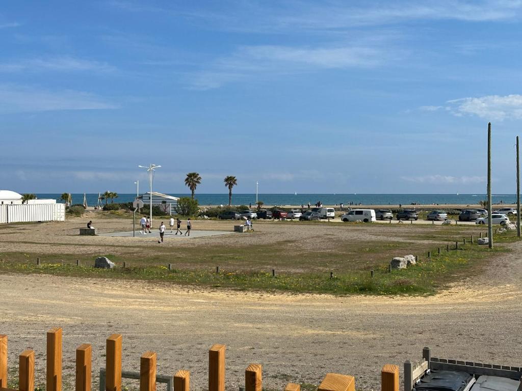 Un grand champ avec des gens dans un parking dans l'établissement Chalet Linoli, à Gruissan