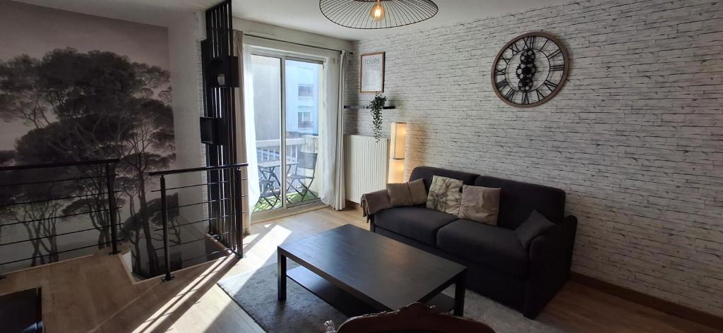 un salon avec un canapé et une table dans l'établissement Appartement calme aux Prébendes, à Tours
