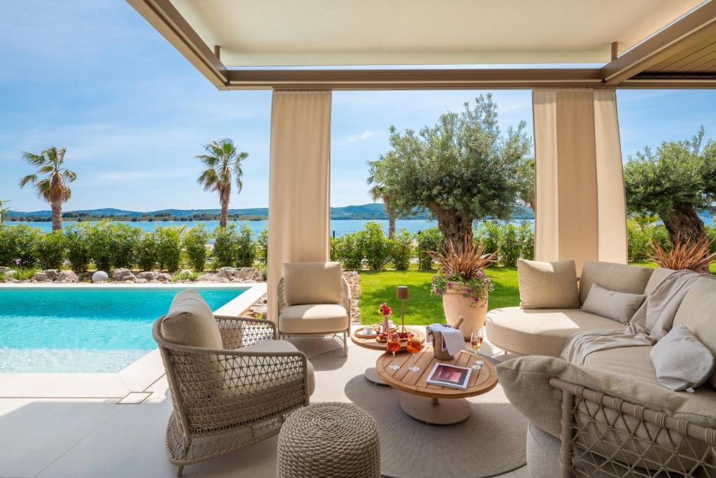 a living room with a couch and chairs and a pool at Villa Piano Turanj - Adriatic Luxury Villas in Turanj