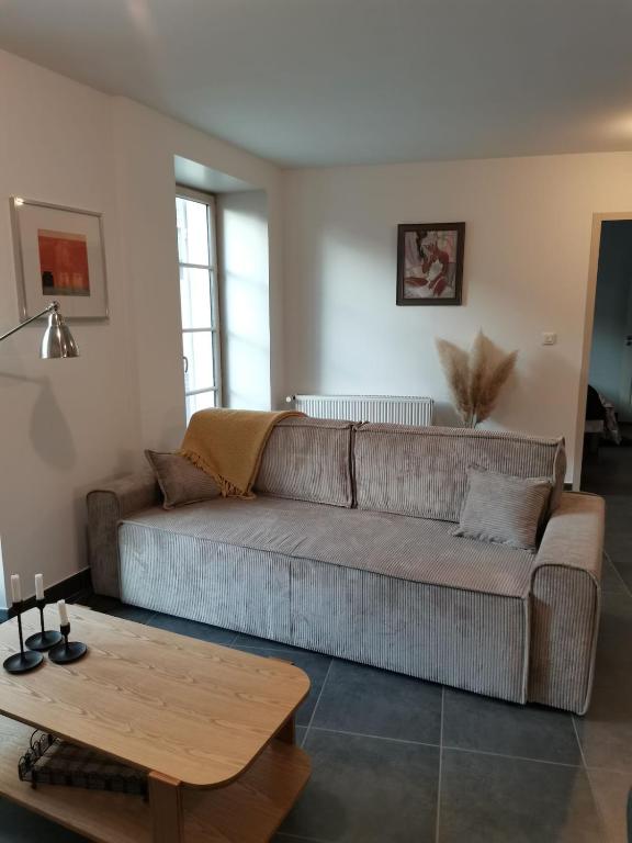 un salon avec un canapé et une table basse dans l'établissement Appartement paisible et spacieux, à Jonzac