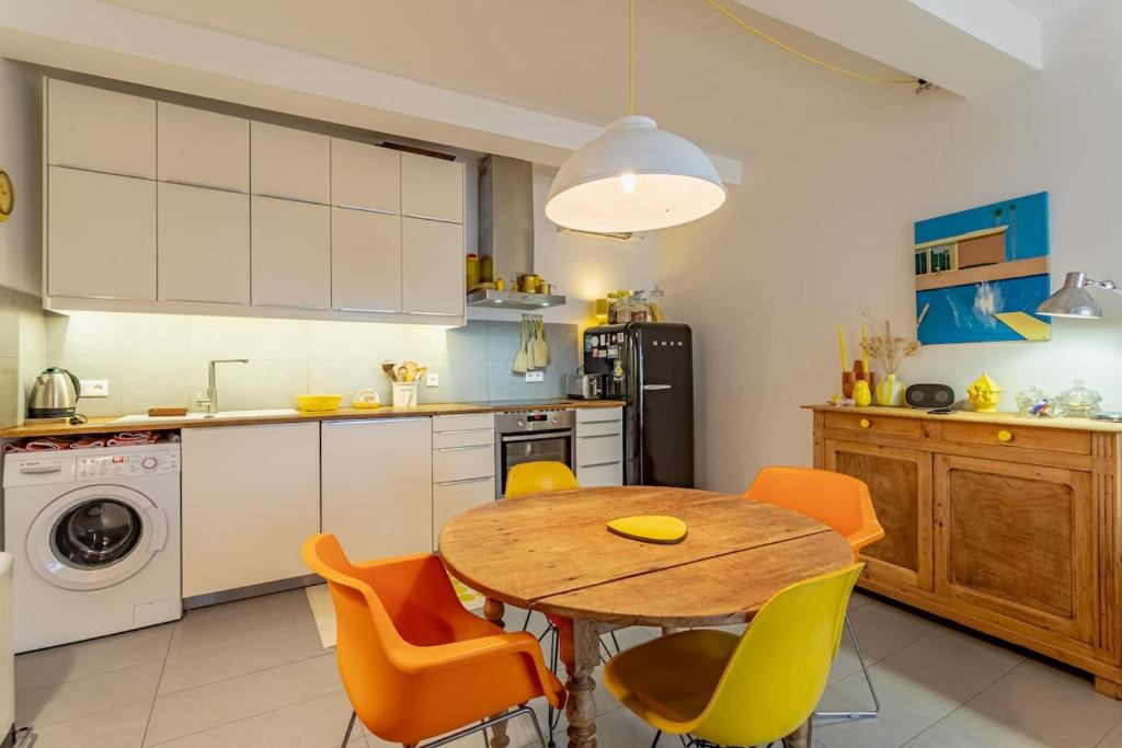 une cuisine avec une table en bois et des chaises jaunes dans l'établissement Jasmine Yellow, à Sérignan