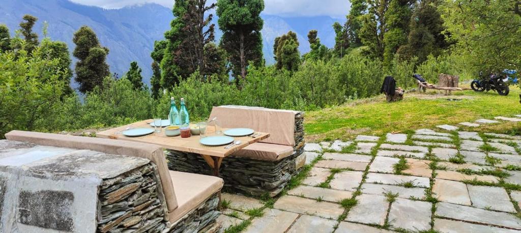 a table and chair sitting on a stone patio at Shantchit Yoga & Wellness Resort Kasol in Jari