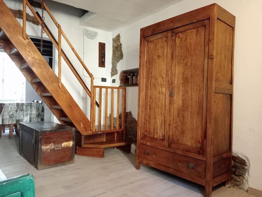 a room with a wooden cabinet and a staircase at La Persellina House in Sant' Agata fossili