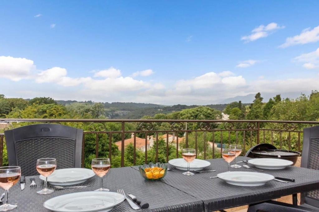 - une table avec des verres de vin sur le balcon dans l'établissement La Frênaie - Quiet - Swimming pool - Car park, à Villeneuve-Loubet
