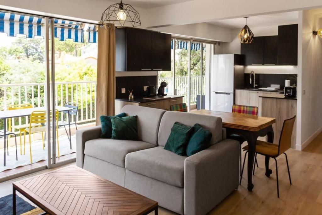 un salon avec un canapé et une table dans l'établissement Le Mimosa - Calm - Spacious - 200m from the sea - Parking, à Cagnes-sur-Mer