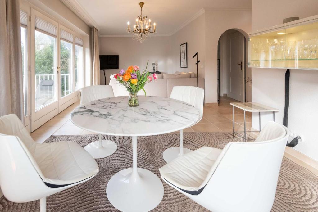a dining room with a white table and white chairs at Haus Gorch Fock Strasse in Westerland
