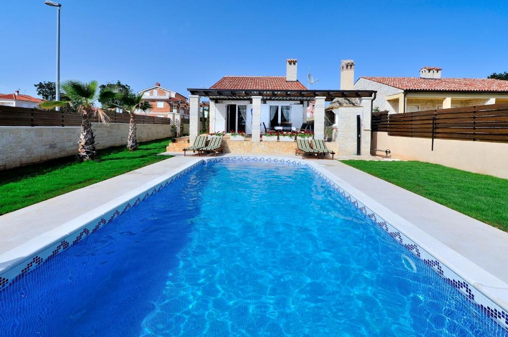 a swimming pool in the backyard of a house at Vila Mila sa privatnim bazenom in Medulin