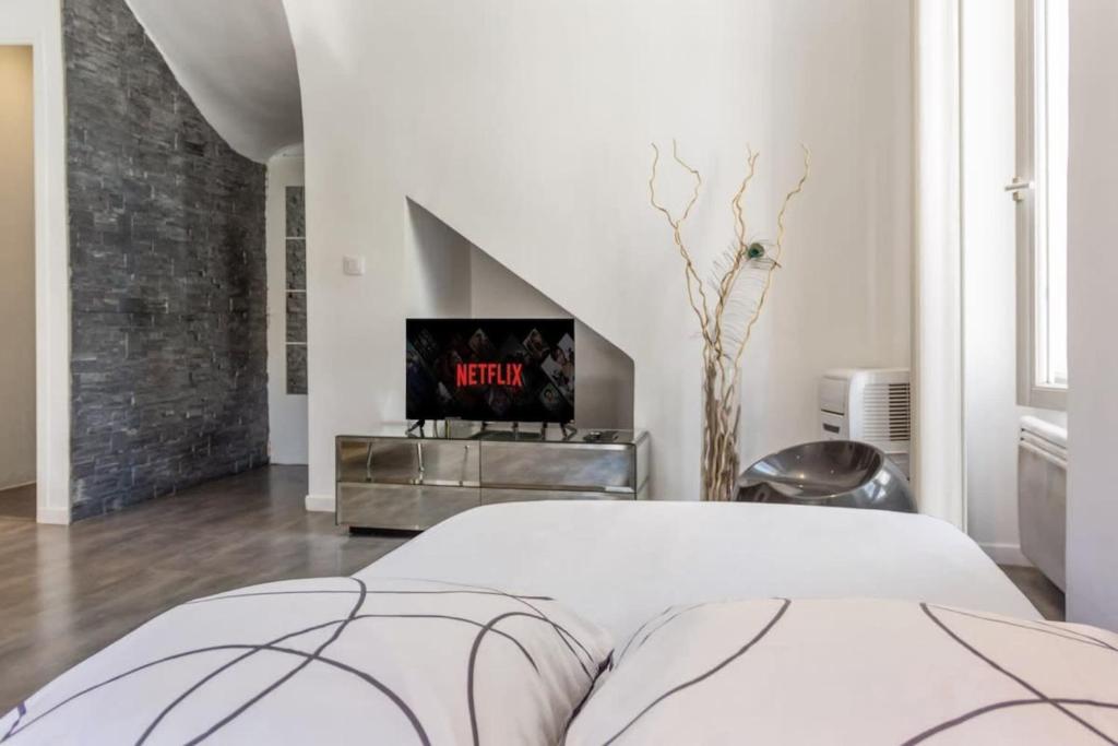 une chambre blanche avec un lit et une télévision dans l'établissement Le Montfleury - Hypercenter - Cozy - WIFI, à Cannes